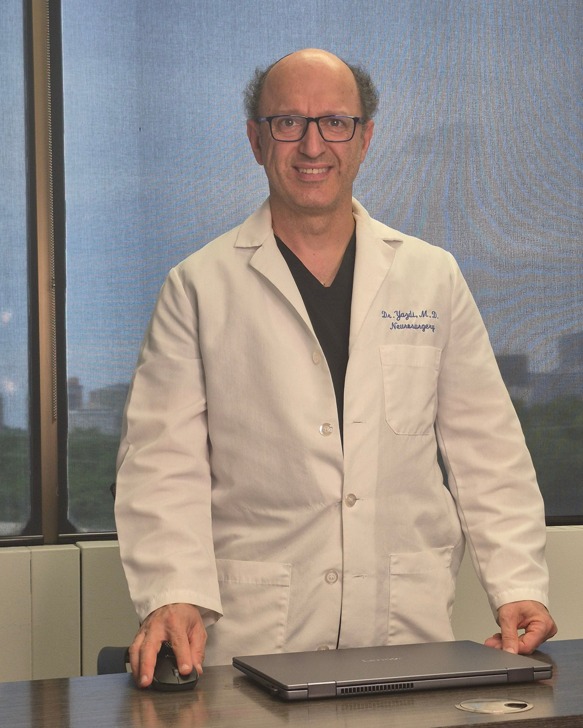 Person in a white lab coat standing at a podium with a screen in the background